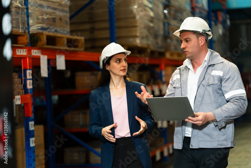 Wallpaper Mural Caucasian adult male supervisor and caucasian adult female executive walking inside warehouse discussing operations while checking logistics report together showing teamwork and strategy. Torontodigital.ca
