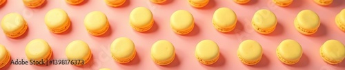 Yellow macaroon cookies arranged in a repeating pattern on a pink background,  vibrant,  baked goods
