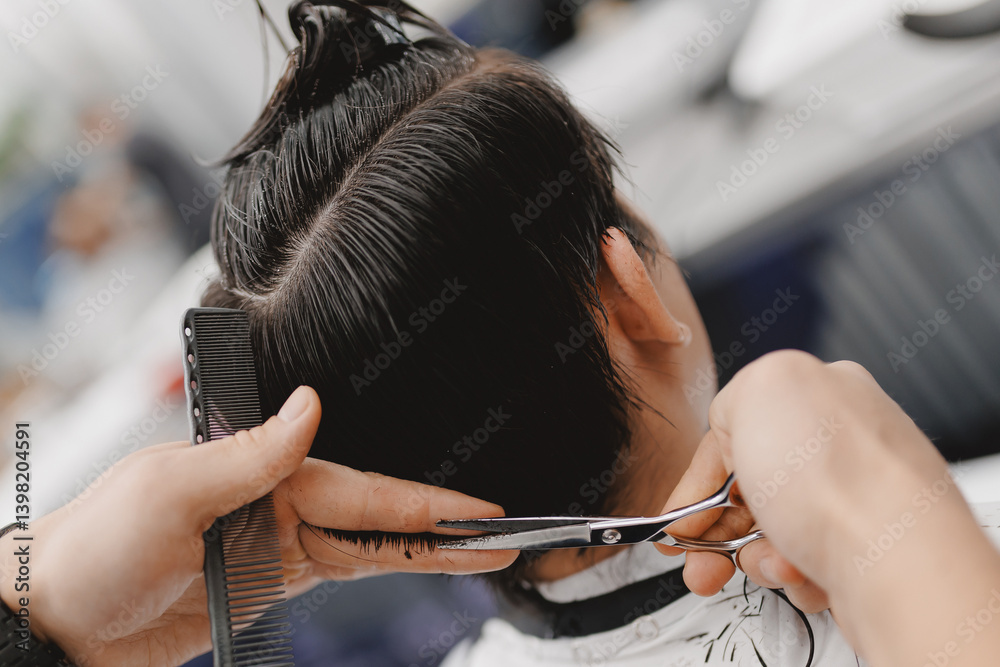 Male haircut at barbershop, precision scissor work on asian teen