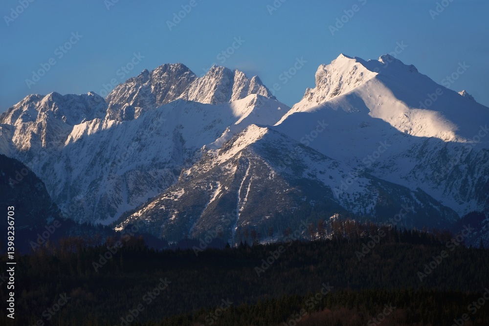 The snow-capped peaks of the High Tatras mountains (with Javorinska Siroka) in sunrise light from viewpoint Pass over Lapszanka (Pass over Łapszanka), Podhale, Poland