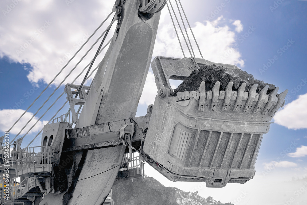 Coal mining excavator working. Heavy machinery in open pit on clear day
