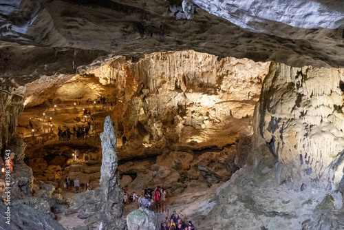Foto Dozens of tourists walk through the dramatically lit main chamber of Hang Sung S