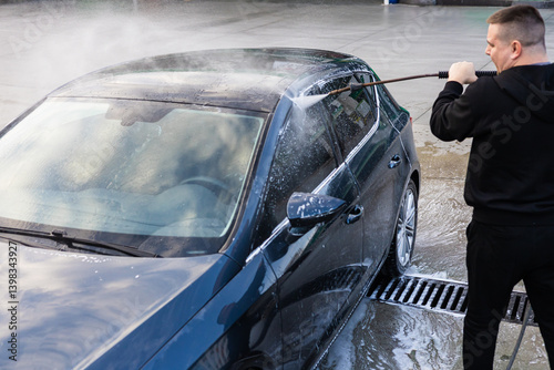 Foto Person using a pressure washer to clean a car at a service station during daytim