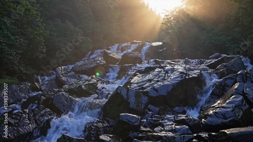 Majestic waterfall cascading over rocks in a serene forest during golden hour