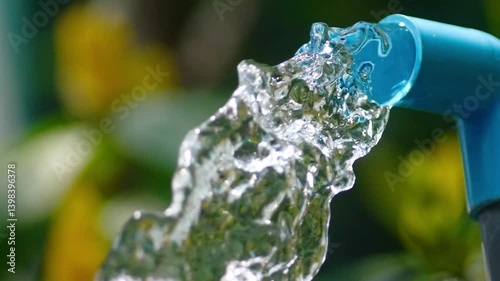 Flowing Water: Pure, refreshing water gushes forth from a blue pipe, its motion captured in a crisp.