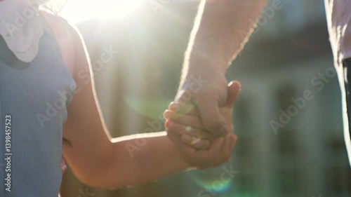 male hand holding child palm, close-up, child kid father go school, father child kid girl daughter, school backpack, family against background school building, sun glare, little girl daughter holding