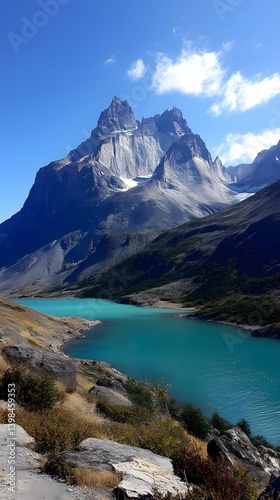 Majestic Peaks Reflecting: The grandeur of towering mountain peaks is mirrored in the serene turquoise waters of a pristine lake under a cloudless azure sky, evoking a sense of wonder and peace.