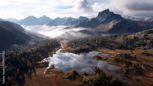 Aerial Shot of Hidden Lake Reflecting Surrounding Mountains and Cloudy Sky in Nature