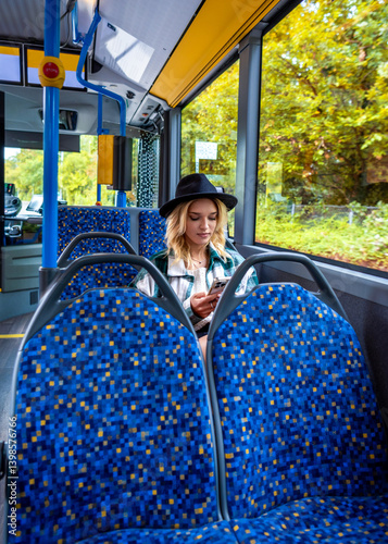 Woman texting while traveling with bus in autumn in the city of Stuttgart, Germany.