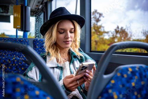 Woman using phone while traveling with bus in autumn in the city of Stuttgart, Germany.