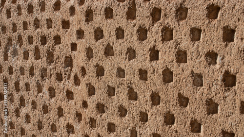 Texture of an old stone wall with small repetitive orifices