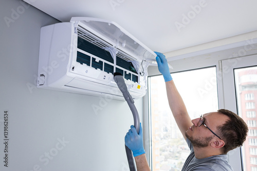 Professional Air Conditioning Maintenance: Man Cleaning and Servicing an AC Unit for Optimal Performance and Efficiency in Modern Indoor Environment