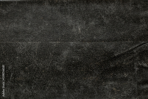 Background of black old leather close-up, the leather is grainy dusty