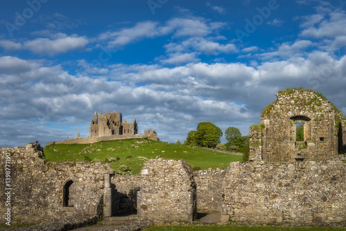 Obraz na płótnie Ancient ruins of Rock of Cashel and Hore Abbey perched on a scenic hill, enveloped by lush greenery and soft clouds, providing a captivating glimpse into a rich history, Tipperary, Ireland w salonie