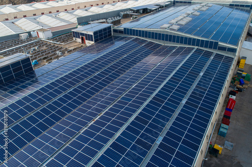 Solar panels covering industrial building roof generating clean energy