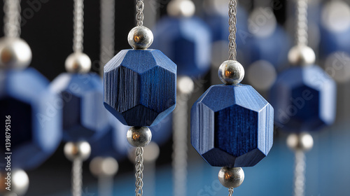 Artistic Blue Beads: A captivating display of dark blue, geometrically shaped beads strung together, forming an aesthetic composition. Metallic silver beads enhance this artwork.
