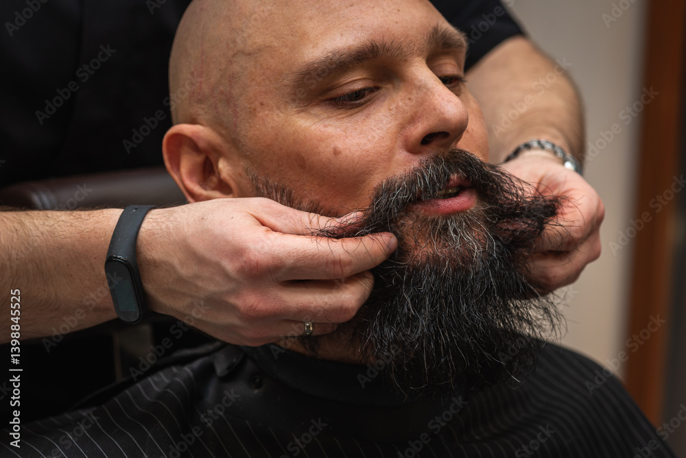 Bearded man at barbershop getting beard groomed and shaped by barber. Close-up of grooming process, professional beard care, stylish male beauty routine