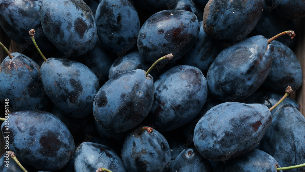 Fototapeta premium Fresh plums in wooden box on rustic table, top view