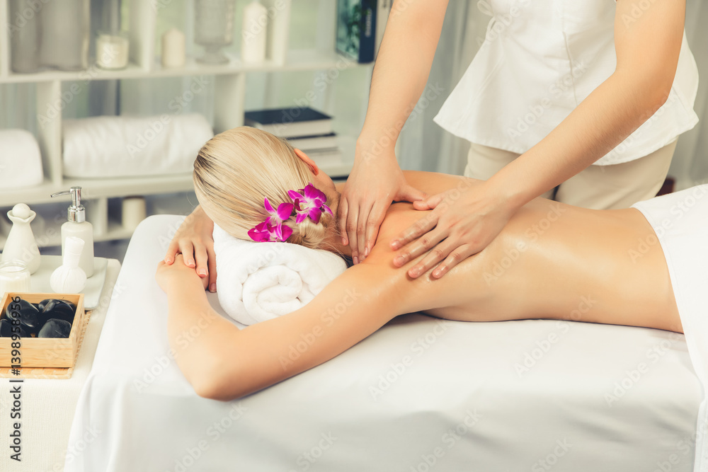 Obraz premium Caucasian woman customer enjoying relaxing anti-stress spa massage and pampering with beauty skin recreation leisure in day light ambient salon spa at luxury resort or hotel. Quiescent