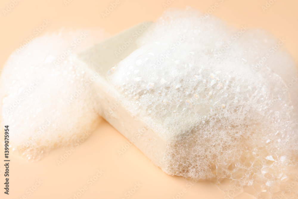Soap bar with foam on beige background, closeup Soap bar with foam on beige background, closeup