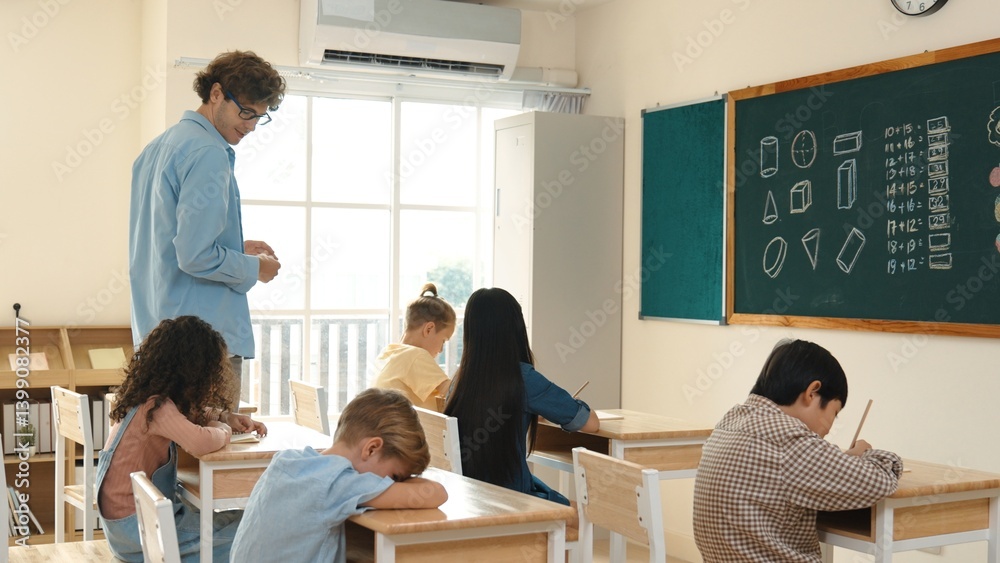 Skilled teacher walking at classroom while looking at student homework. Professional instructor checking smart children notebook while student doing test or working on homework at classroom. Pedagogy. Skilled teacher walking at classroom while looking at student homework. Professional instructor checking smart children notebook while student doing test or working on homework at classroom. Pedagogy.