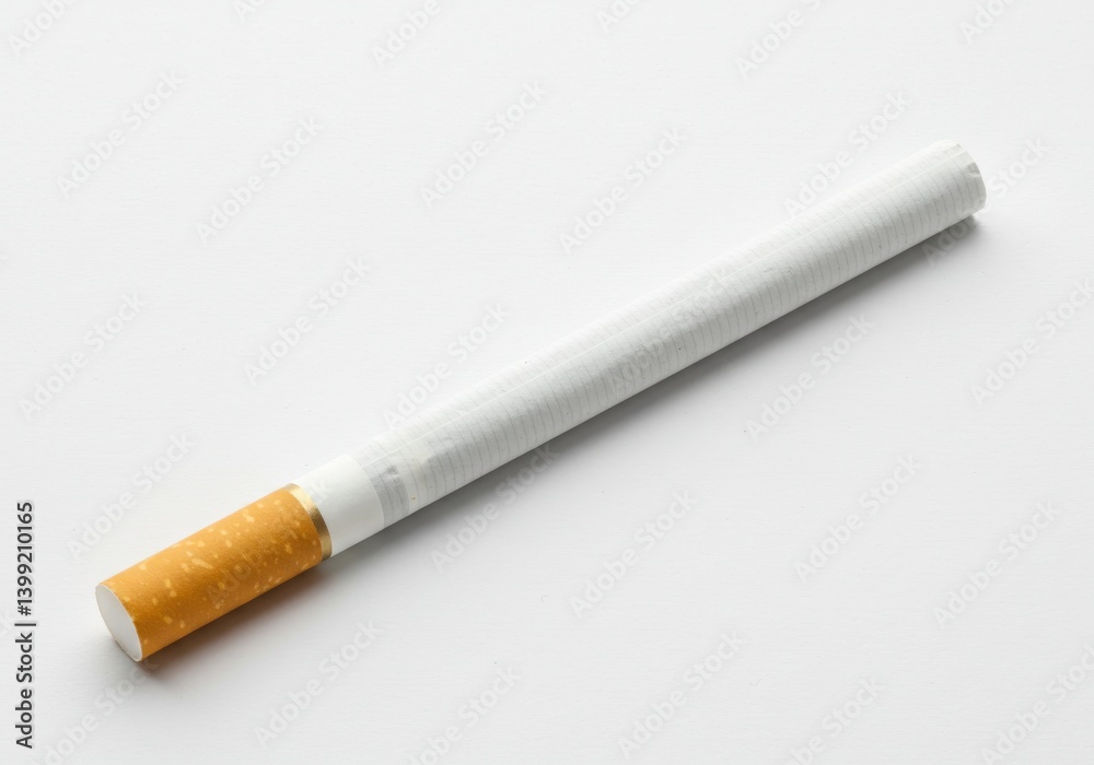 A single cigarette with a white body and brown filter on a plain white surface in close up view A single cigarette with a white body and brown filter on a plain white surface in close up view