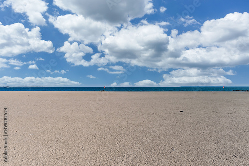 Coney Island beach and boardwalk with oceanfront condos nearby. A scenic view capturing coastal living, recreation, and classic New York charm on a sunny day.