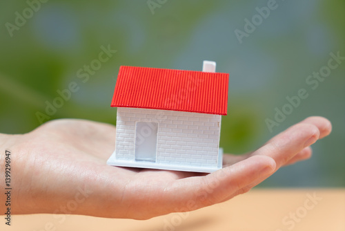 Obraz na płótnie A Hand Holding a Model House Signifying Homeownership and Care w salonie