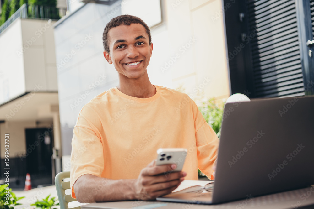 Young afro-american male enjoying casual day outdoors with technology, wearing trendy t-shirt in urban setting Young afro-american male enjoying casual day outdoors with technology, wearing trendy t-shirt in urban setting