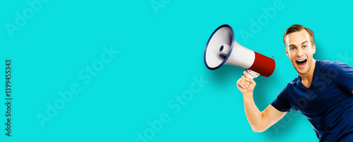 Funny happy expressive man in t-shirt advertise use mega phone loudspeaker bullhorn, isolate blue green color background. Black Friday sale price discount ad concept. Banner image with free text space