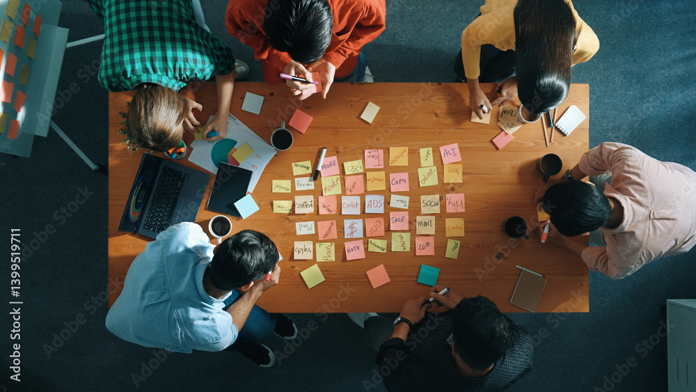Top down view of smart diverse business people writing marketing idea at meeting and brainstorming start up project strategy or campaign at meeting room. Creative group discussing plan. Convocation.