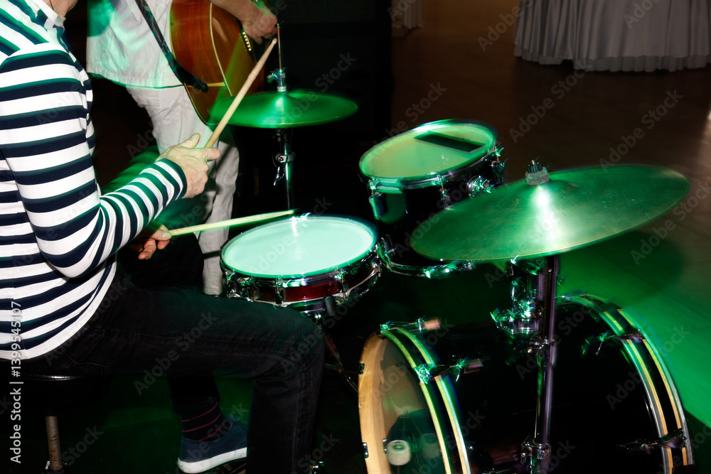 Obraz premium A man is playing drums in a green room