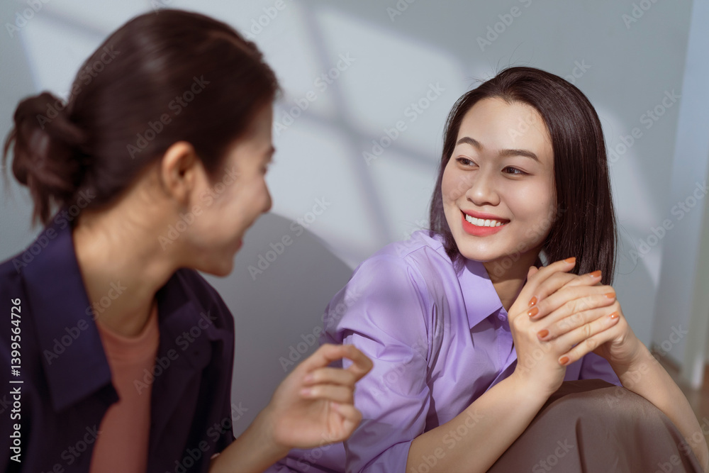 Women engaged in lively conversation and laughter in a bright, modern setting during the afternoon Women engaged in lively conversation and laughter in a bright, modern setting during the afternoon