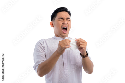 Unhealthy Asian Muslim man suffering flu-sick, sneezing loudly in tissue isolated on transparent background