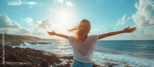 Woman embraces ocean sunset, coastal rocks background, freedom concept