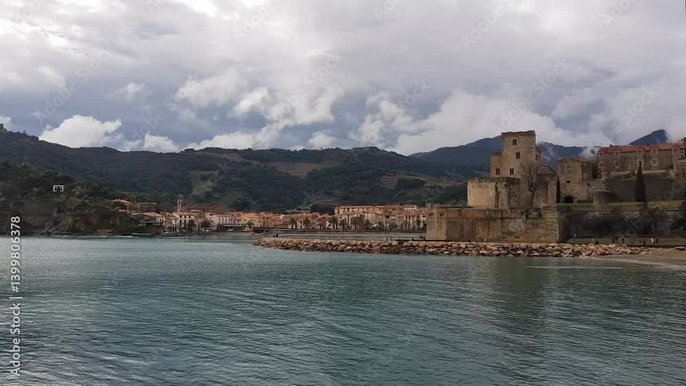 The tranquil coastline features a blend of ancient castle ruins and charming village houses. Collioure, France The tranquil coastline features a blend of ancient castle ruins and charming village houses. Collioure, France
