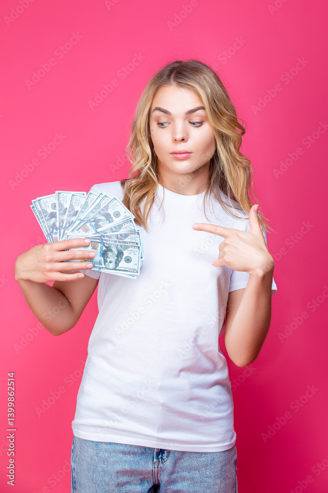 Financial Concepts. Winsome Caucasian Girl Posing WIth Bunch of American Currency Banknotes Against Coral Background. Financial Concepts. Winsome Caucasian Girl Posing WIth Bunch of American Currency Banknotes Against Coral Background.