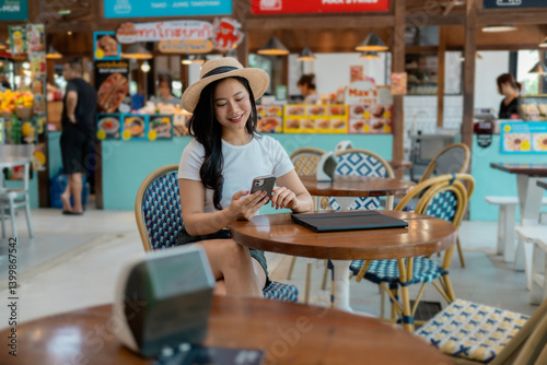 Tourist using smartphone in food court enjoying summer holidays
