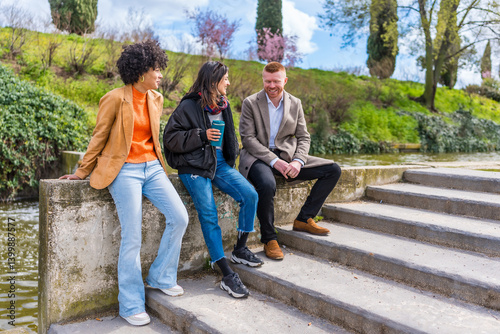 Group of young professionals relaxing by canal in urban park