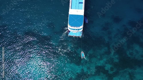 Drone aerial shot of Similan Islands in the Andaman Sea in Thailand with liveaboard scuba diving boats in the bay surrounded by beautiful tropical blue water and rocky island with jungle and waves