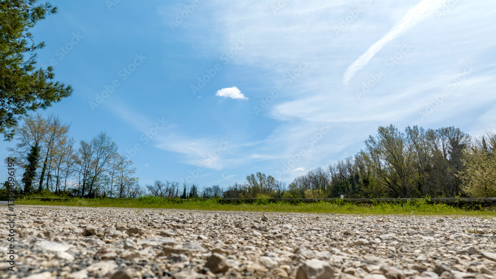 Bottom view of a land with pebbles and the blue sky in the background.