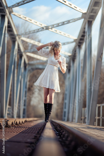 Young woman in white dress on the tracks