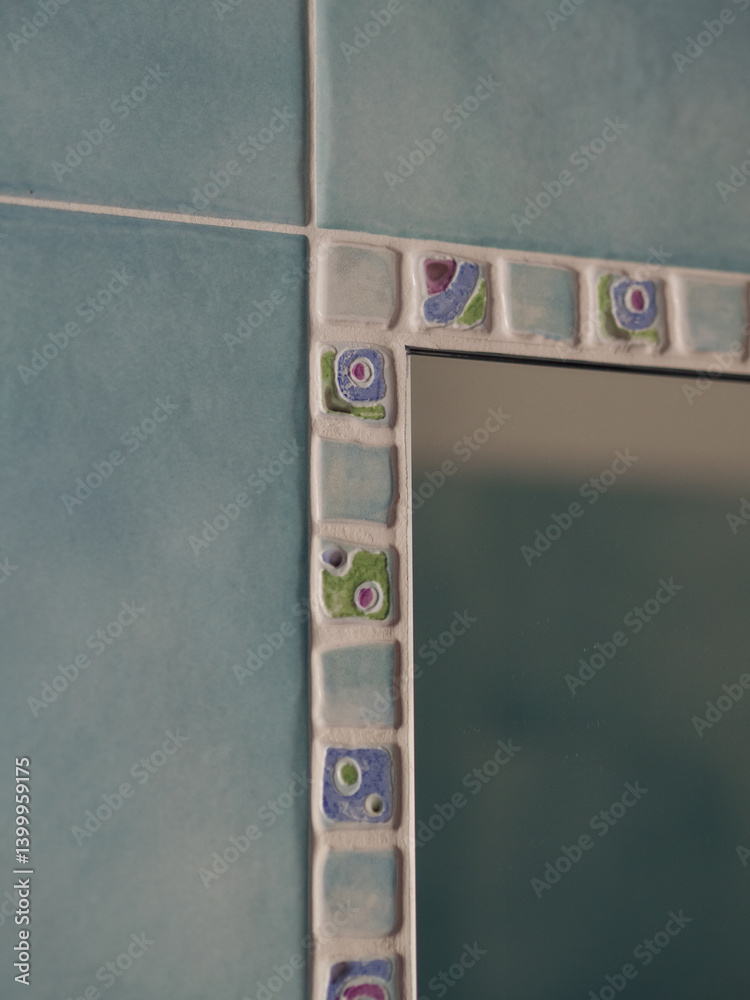 Obraz premium Mosaic-Framed Mirror on Blue Tiled Wall, Vertical Close-Up of Italian Bathroom Detail