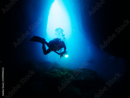 Wallpaper Mural scuba diver diving inside a marine cave that illuminate with a flashlight, concept of active leisure lifestyle and underwater adventure, copyspace for text Torontodigital.ca
