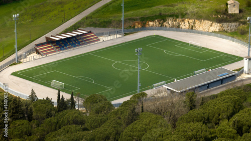 Obraz na płótnie Aerial view of an empty football pitch. It has a small stand and synthetic grass. w salonie