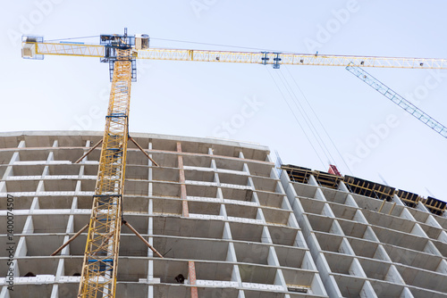 Obraz na płótnie High-rise building under construction with cranes w salonie