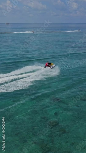 Aerial drone top view footage of two jet ski competition in tropical water of Indian Ocean. Couple riding by watercraft with high speed.Maldives.Vertical video