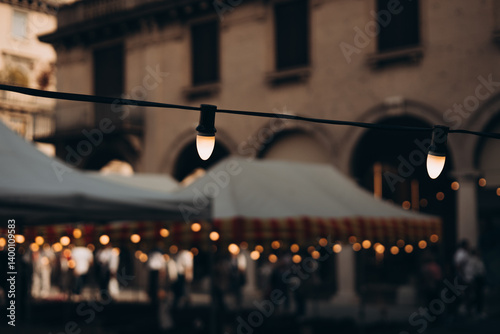 Obraz na płótnie Decorative vintage street black light bulbs with white shade. Outdoor Street electric garland. Old light bulbs. String wired bulbs. Festoon string lights decoration at the party event. w salonie