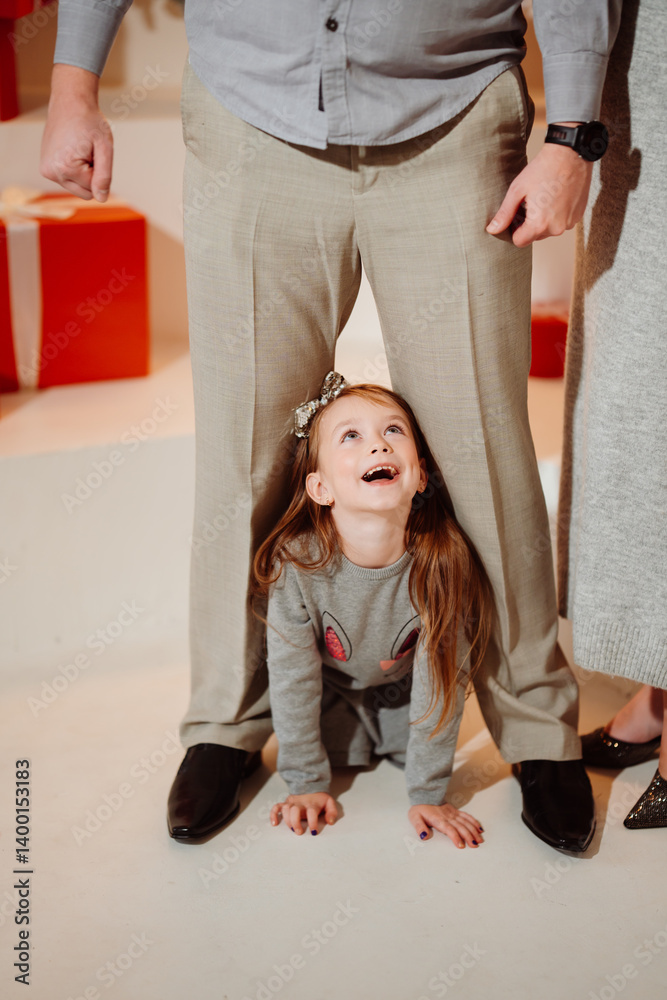 Funny girl crawling between daddy's legs. new year holiday