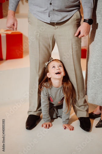 Obraz na płótnie Funny girl crawling between daddy's legs. new year holiday w salonie